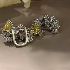 Macro shot of vintage style yellow resin flower earrings with shimmering crystal accents