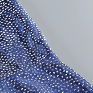 Macro shot of sparkling silver rhinestones on luxury royal blue satin evening dress fabric