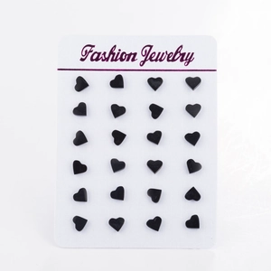 Set of twelve pairs of glossy black heart-shaped stud earrings on a white jewelry card
