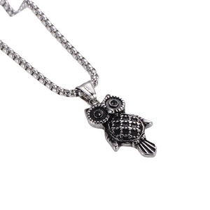 Retro owl pendant necklace in silver stainless steel with black stone eyes on white background