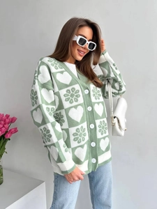 Détail du cardigan en maille à carreaux vert clair avec motifs de cœurs et de fleurs