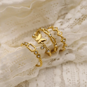 Set of four gold butterfly and floral stainless steel rings with sparkling diamonds