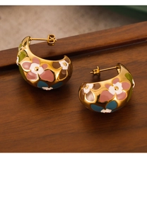 Detailed close-up of C-shaped gold-plated earrings with colorful enamel flower patterns