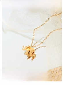 Detail of 18K gold plated elephant pendant necklace on reflective mirror surface