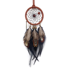 Handmade brown dream catcher car charm with feathers and beads on a white background