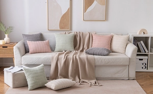 Living room setup with corduroy cushion covers and knitted blankets in soft colors