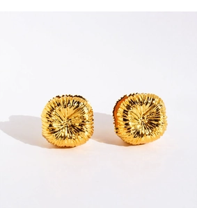 Detailed macro view of golden shell earrings with unique radial sunburst textures