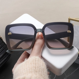 Oversized black square sunglasses with gradient lenses and gold logo for women