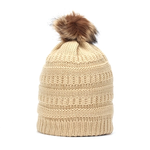 Detailed knit texture of a thick winter beanie with a fluffy brown faux fur pompom