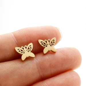 Macro shot of gold butterfly stud earrings featuring intricate hollow filigree details