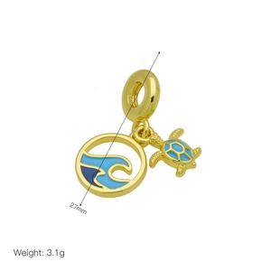 Detailed view of a gold ocean charm with wave pendant and small turtle for bracelets