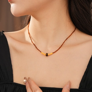 Close-up of vintage tiger eye stone bead necklace worn by a model on the neck