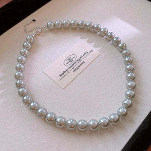 Close-up of grey-blue pearl necklace with silver lobster clasp and adjustable metal chain