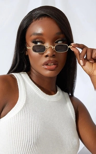 Side view of golden slim metal frame sunglasses with black rectangular lenses on a model