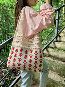 Detailed close-up of handmade knit tote bag with red strawberry pattern and mesh design