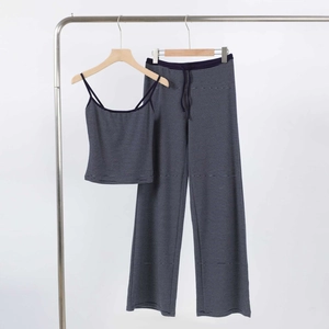 Détail d'un ensemble caraco et pantalon à rayures bleu marine sur cintres en bois