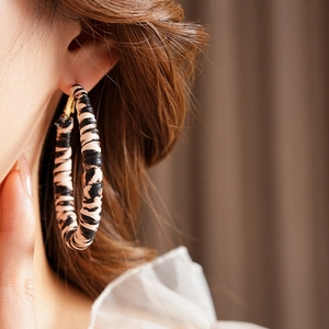 Close-up of a leopard print large hoop earring on model showing vintage chic style