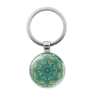 Macro detail of Mandala Flower of Life glass gem pendant on a metal keychain
