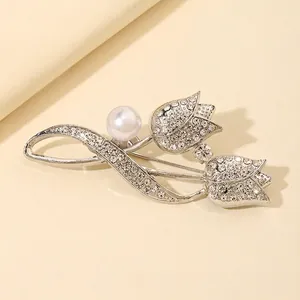 Detailed macro view of silver tulip brooch with sparkling rhinestones and white pearl