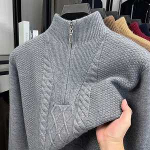 Detail der grauen Zopfstrick-Textur und des Reißverschlusskragens am warmen Herrenpullover