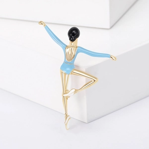 Elegant ballet dancer brooch with blue enamel and gold finish on minimalist white pedestal