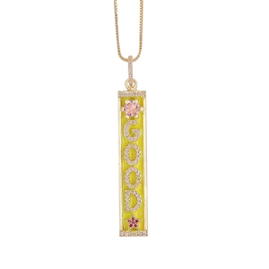 Detail of 18K gold rectangle pendant with GOOD lettering and micro-pave crystals
