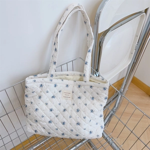 Détail du sac cabas matelassé à fleurs avec surpiqûres en losange et étiquette tissée