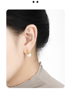 Detail of vintage twist earrings with pearls on ear for a minimalist French style look