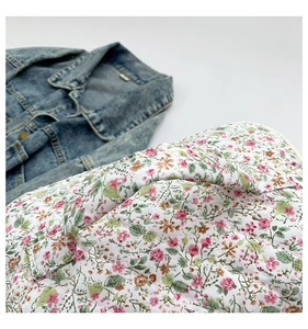Close-up of floral quilted fabric texture and diamond stitching on a cosmetic bag