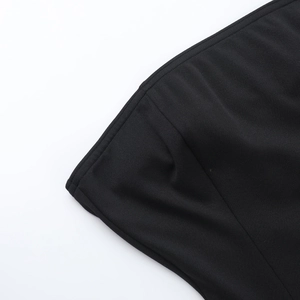 Close-up of the black knit fabric texture and high-quality stitching on the dress hem