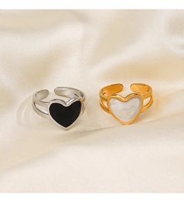 Flat lay of heart-shaped open rings in gold and silver finish on silk fabric