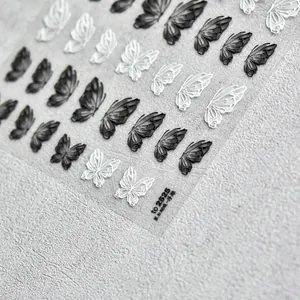 Gros plan détaillé d'autocollants 5D pour ongles avec papillons en relief noir et blanc