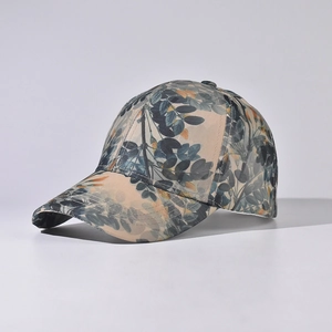 Detail view of cotton baseball cap with blue leaf prints and curved brim against grey background