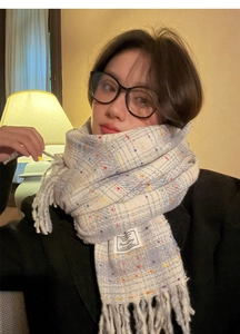 Close-up of gray and white plaid scarf with colorful polka dots and fringe details