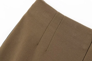 Dettaglio del tessuto twill marrone con cuciture precise sui pantaloni autunnali