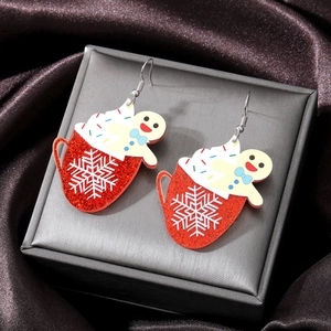 Macro shot of gingerbread man and red mug acrylic earrings in a luxury jewelry gift box