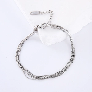 Multi-layered stainless steel silver bracelet for women on white marble background