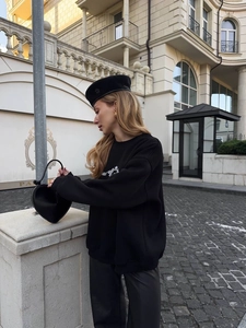 Outdoor shot of loose black street style sweatshirt with white letter print detail