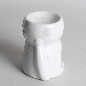Close-up of white ceramic aromatherapy burner with gold speckles and matte finish