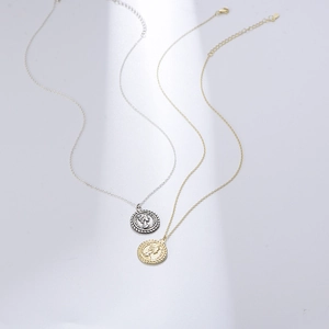 Detail view of silver and gold S925 sterling silver necklaces with Queen Elizabeth II coin pendants