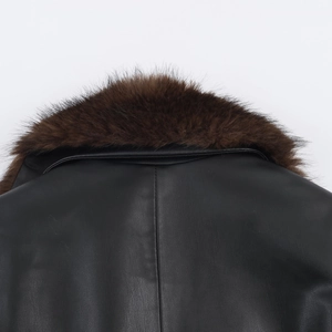 Detail of premium black leather jacket showing plush brown fur collar and fine texture