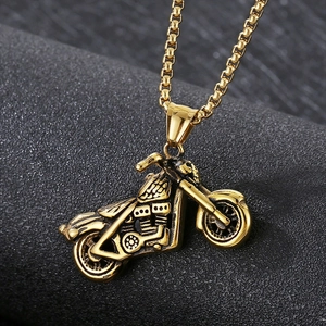 Macro shot of 3D gold motorcycle pendant with intricate metal engraving and box chain