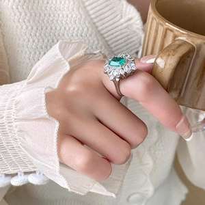 Dettaglio macro dell'anello con pietra verde smeraldo e zirconi a taglio marquise