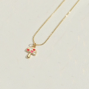 Close-up of gold mushroom pendant necklace with red and white hearts on O-chain