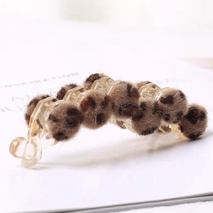 Detail shot of plush leopard print banana hair clip with soft faux fur texture