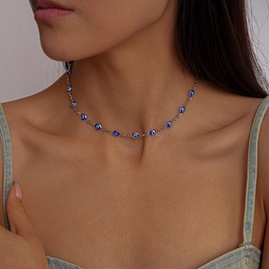 Close-up of exotic evil eye beaded necklace in silver chain worn by a female model