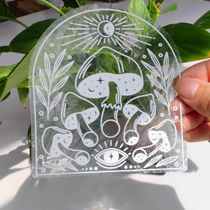 Detail of mystical suncatcher sticker with mushroom and celestial moon graphics