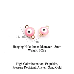 Detailed view of pink enamel evil eye charm with dimensions 11.1mm and double gold loops