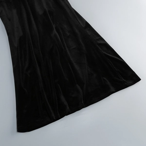 Detailed close-up of the elegant black velvet dress hem with smooth satin fabric texture