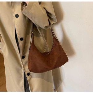 Brown frosted suede crescent bag shown with a khaki trench coat for a chic vintage style